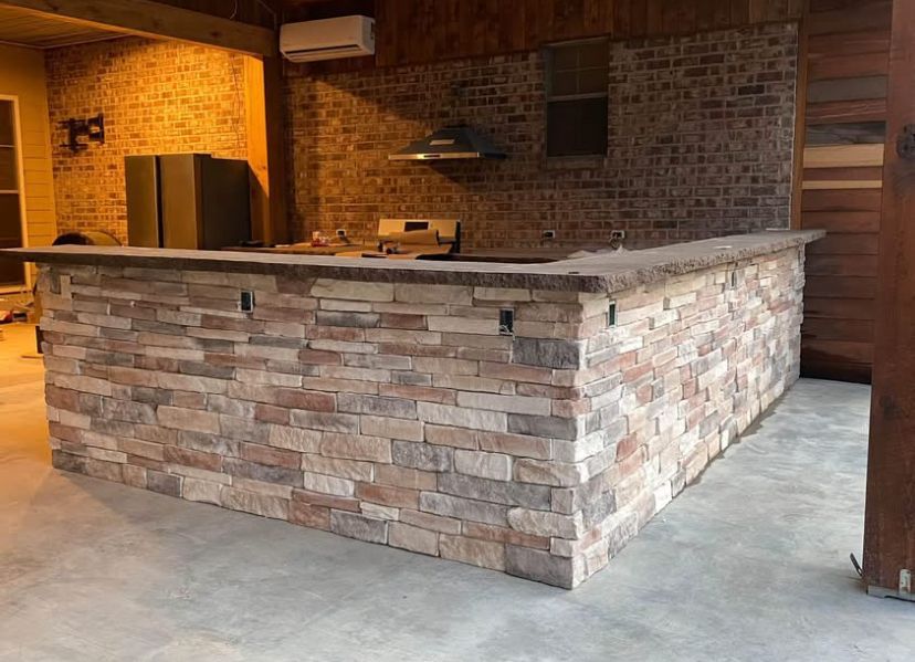 A kitchen with a brick counter top and a refrigerator.