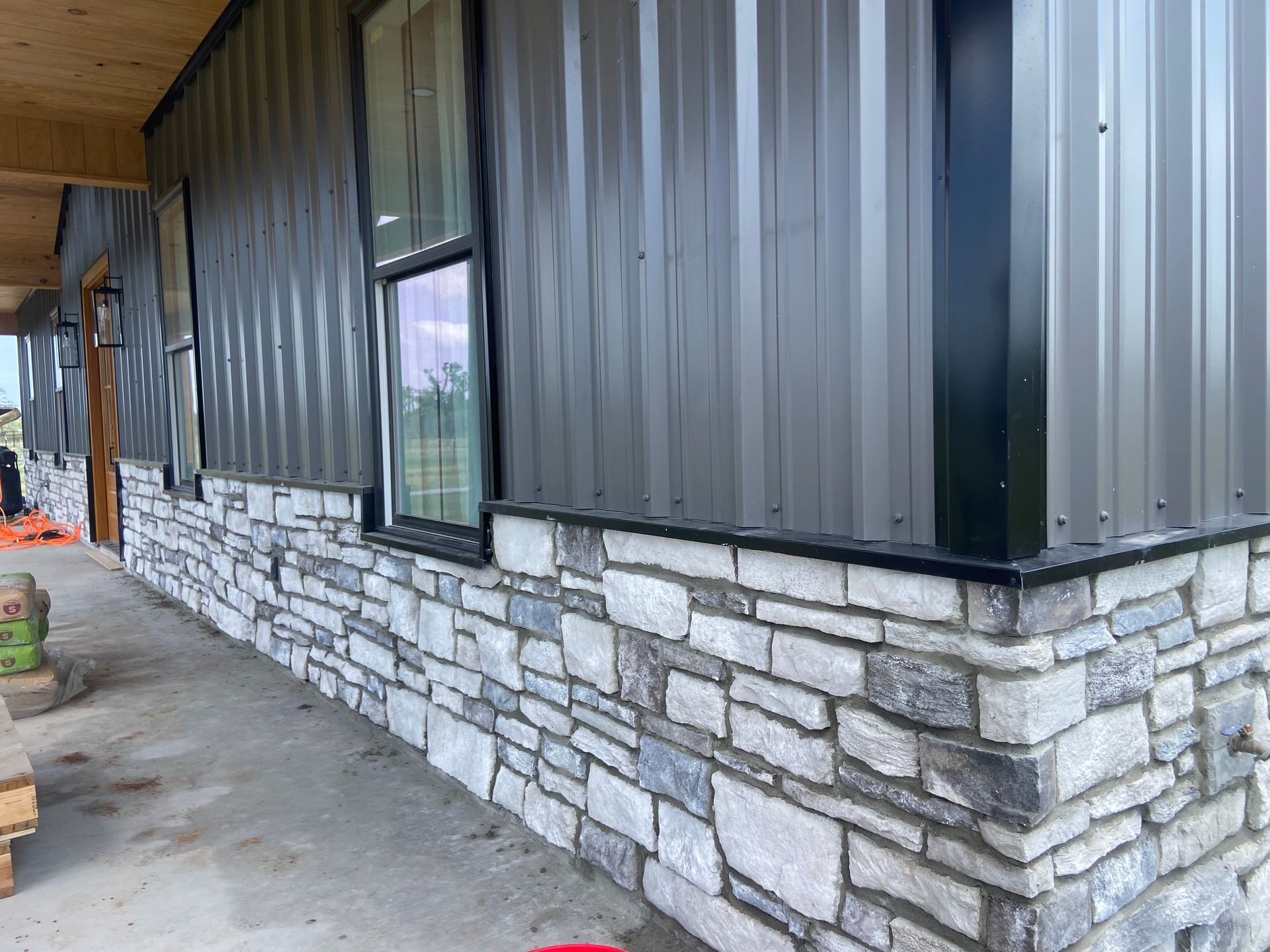 A house with a metal siding and stone siding is being built.