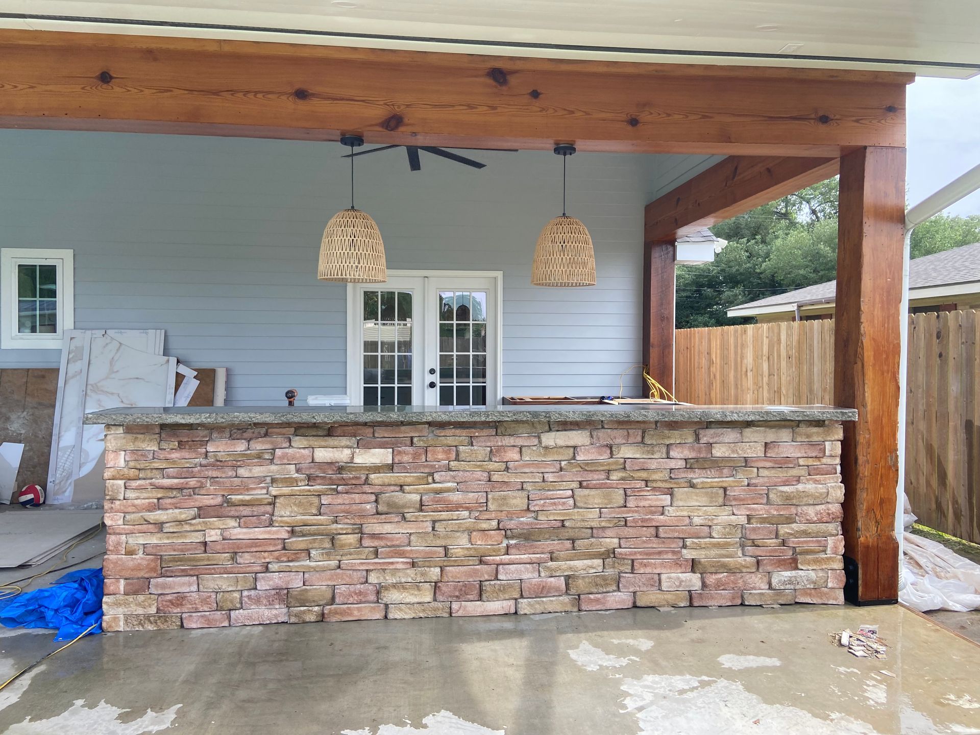 A brick wall is being built on the side of a house.