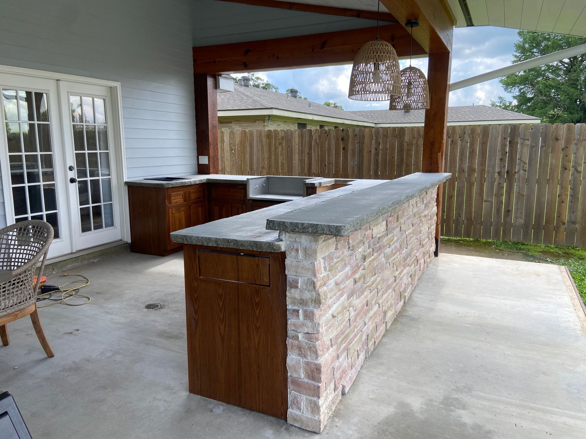 A patio with a brick bar and a wooden table