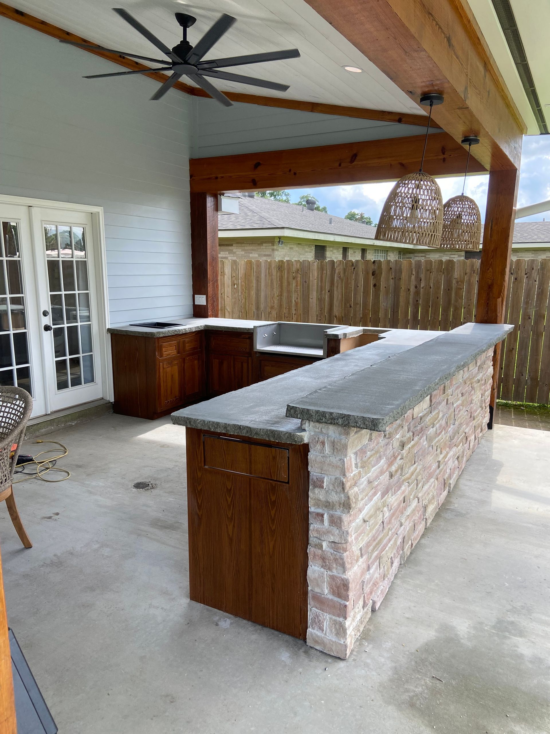 A kitchen with a brick counter top and a ceiling fan.
