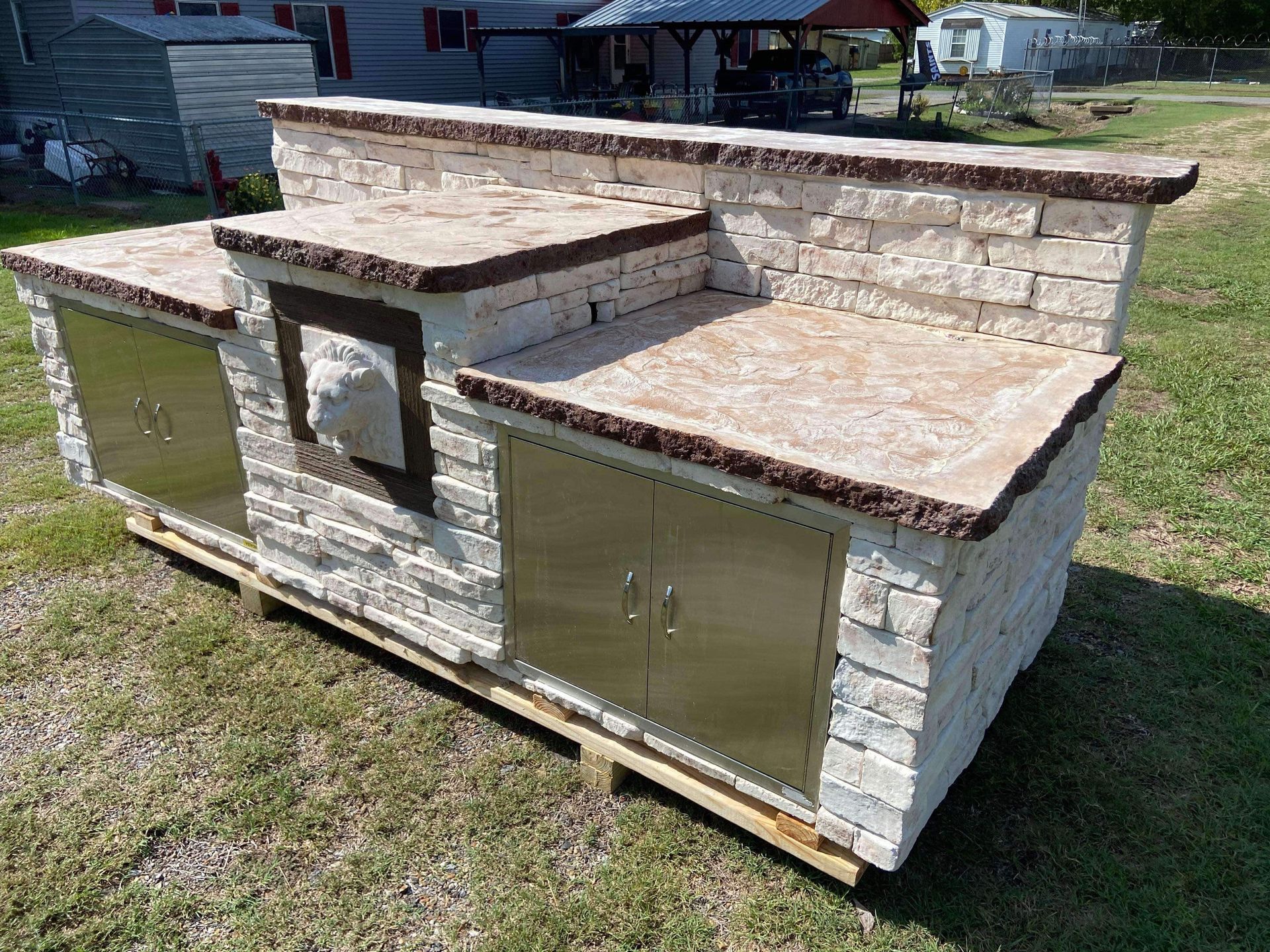 A brick counter top with stainless steel cabinets is sitting on top of a wooden pallet.