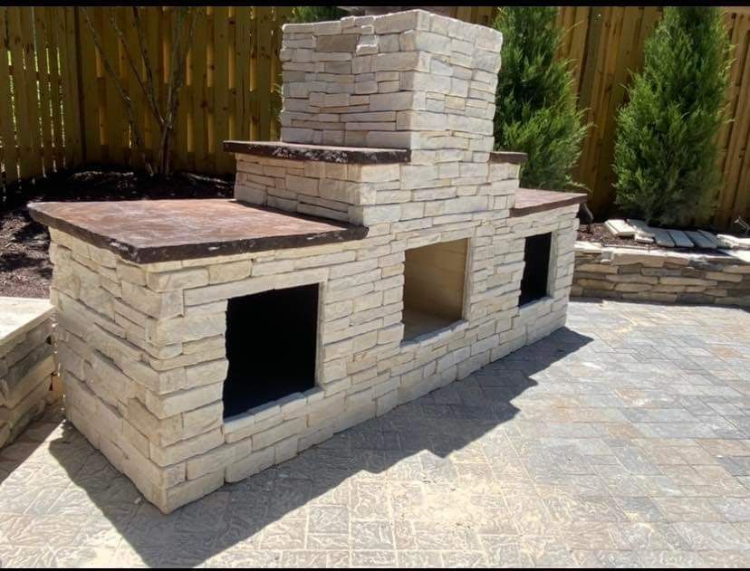 A brick fireplace with a wooden fence in the background