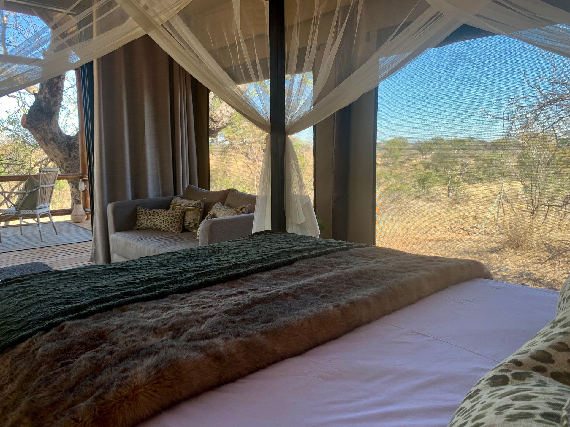 A bedroom with a canopy bed and a couch.