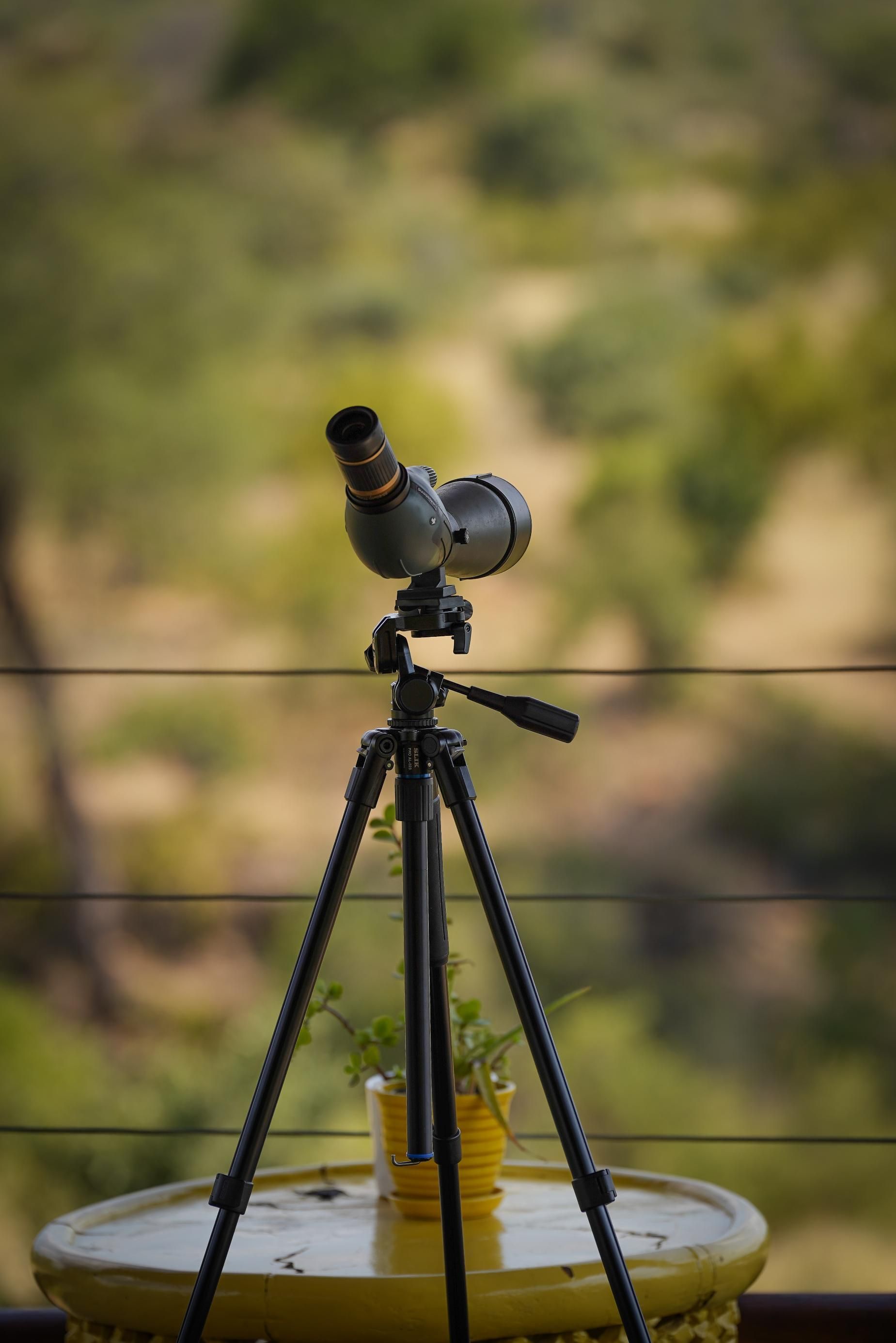 A telescope is sitting on top of a tripod on a table.