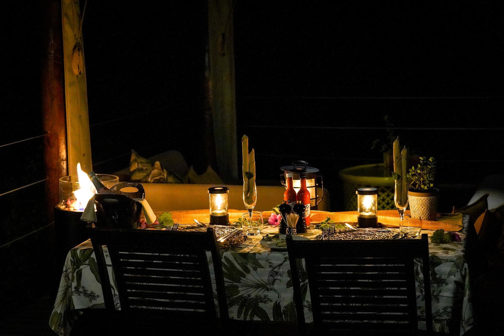 A table with lanterns and candles on it in the dark.
