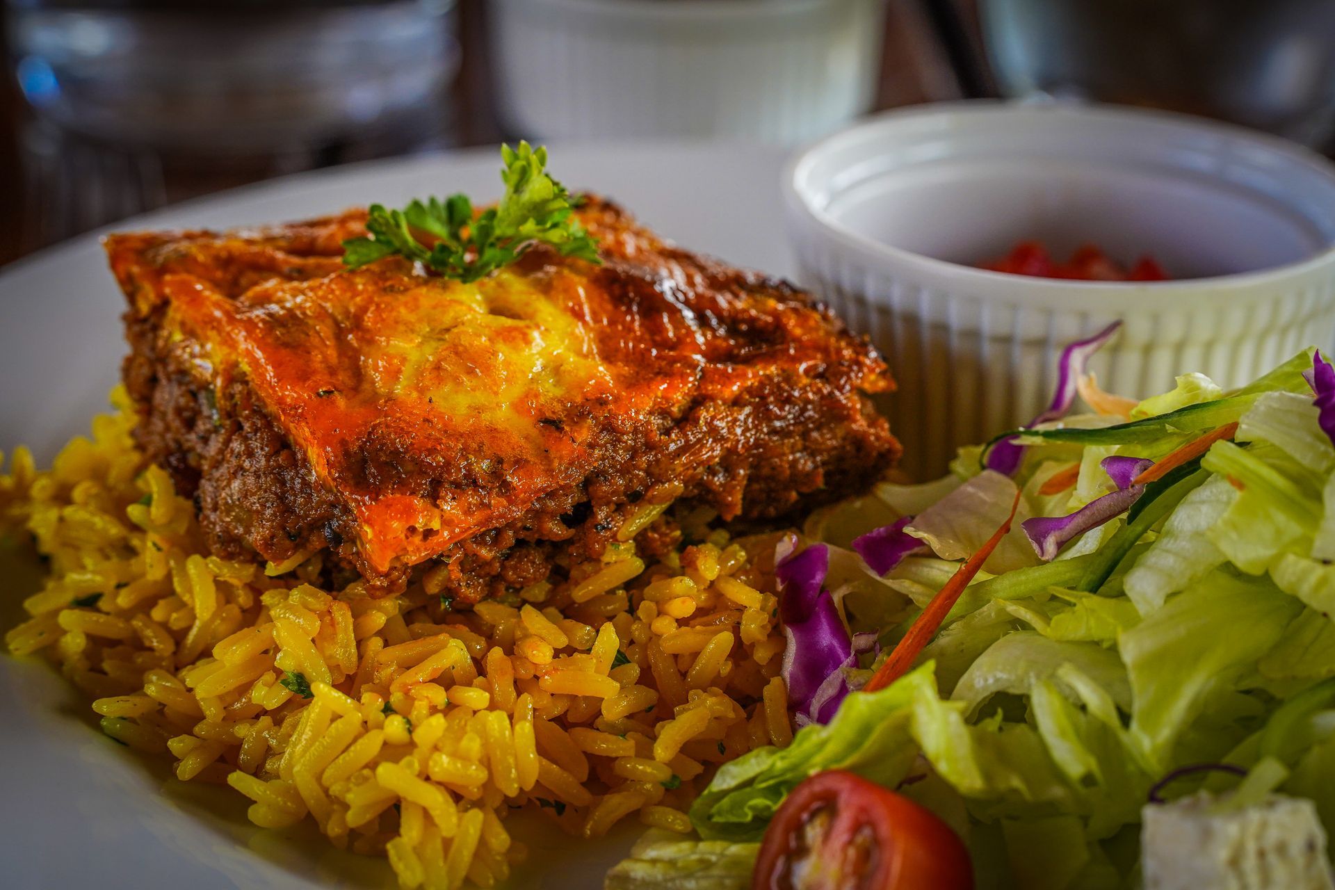 A plate of food with rice and a salad on a table.