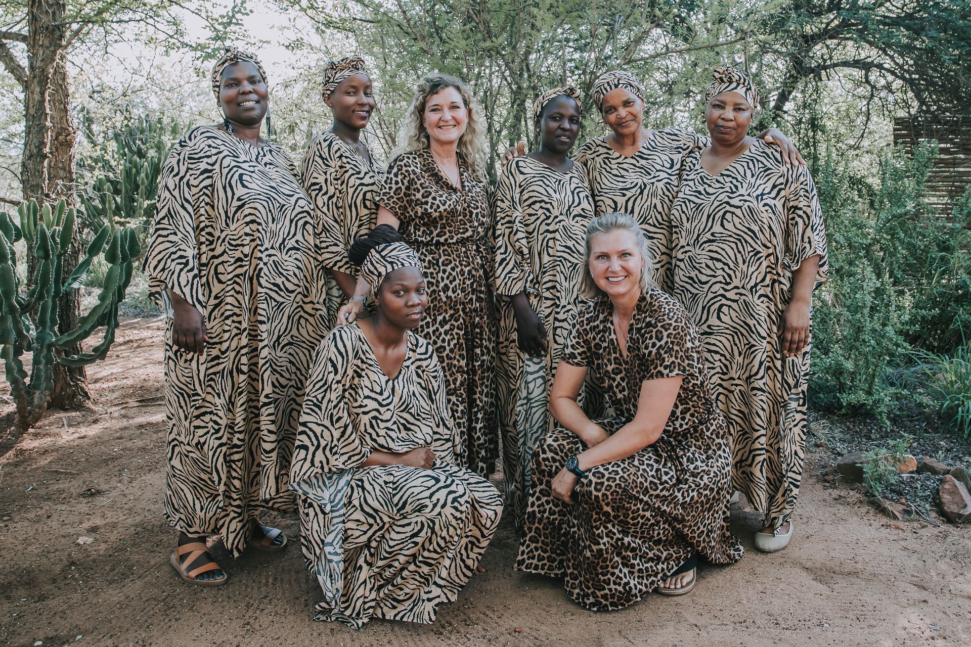 A group of women in leopard print dresses are posing for a picture.