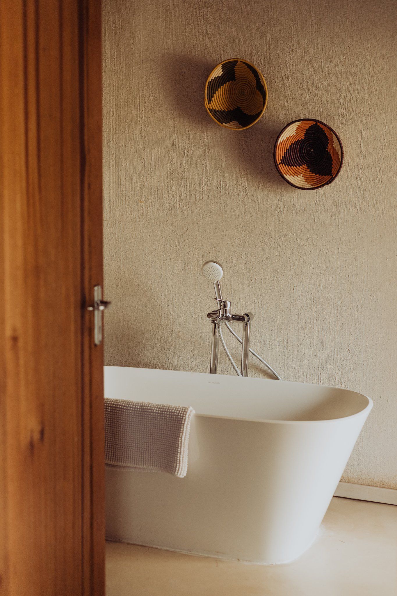 a bathroom with a bathtub and two baskets on the wall