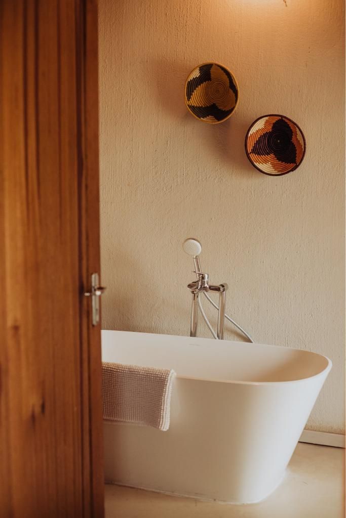 A bathroom with a bathtub and two baskets on the wall.