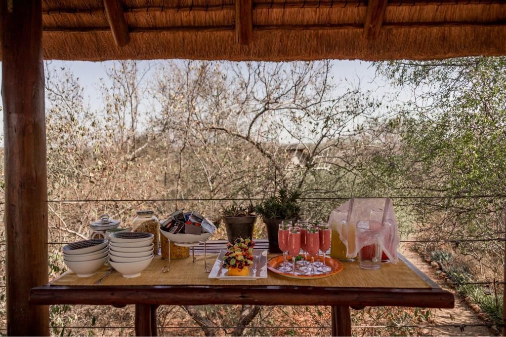 There is a table with a lot of food and drinks on it.