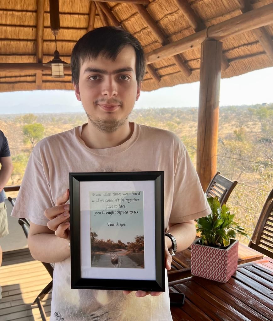 A young man is holding a framed picture in his hands.