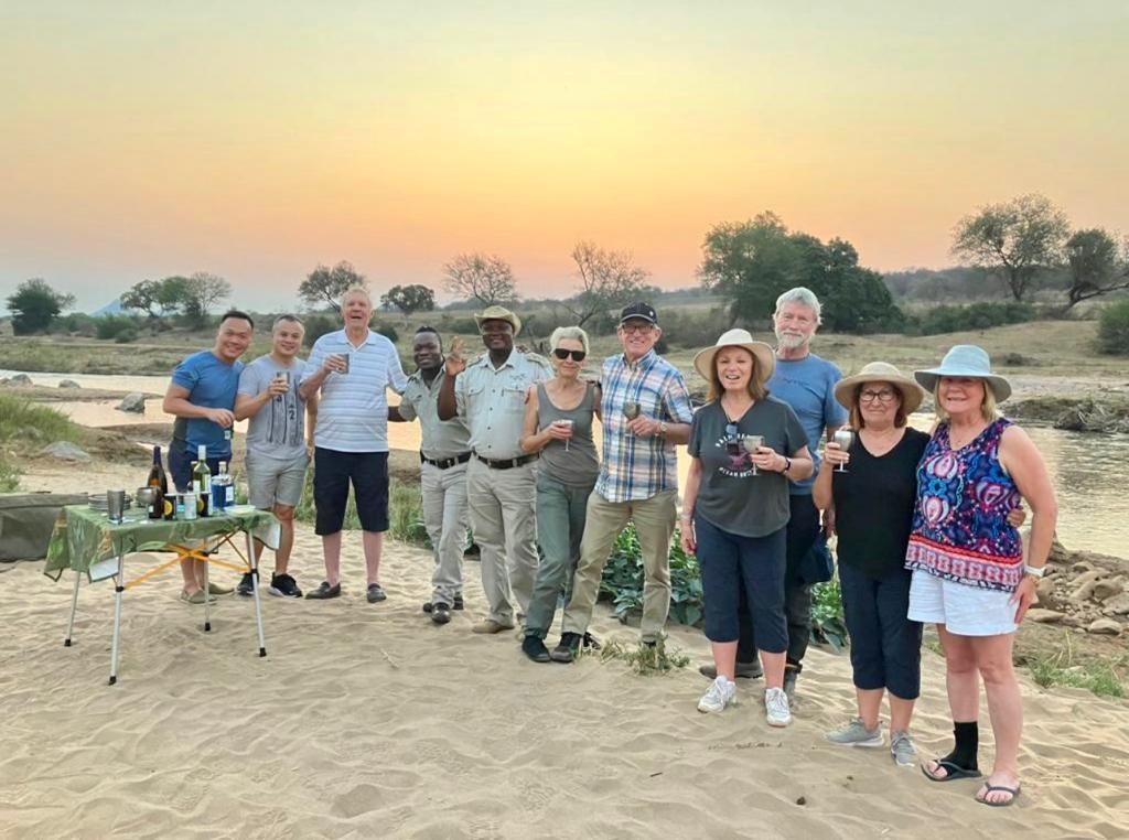 A group of people are standing next to each other on a sandy beach.