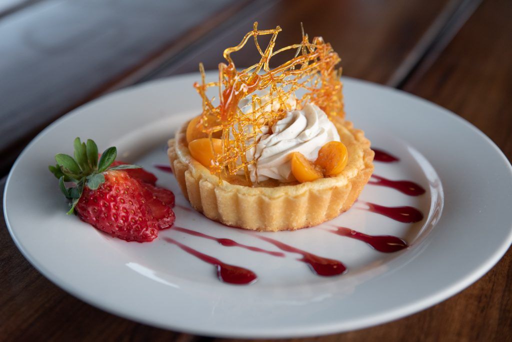 a white plate topped with a dessert and a strawberry