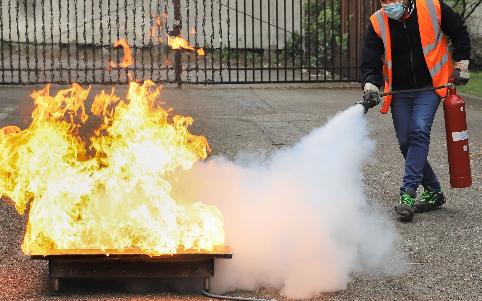 A man is using a fire extinguisher to put out a fire