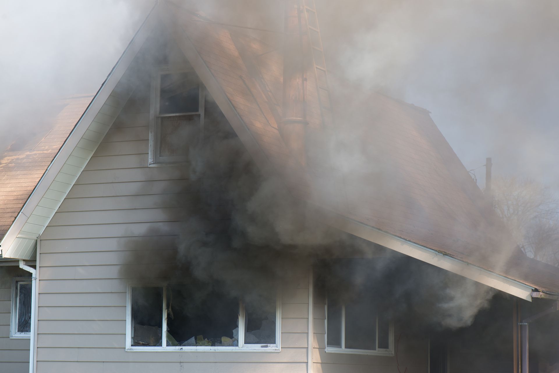 Smoke is coming out of the roof of a house.