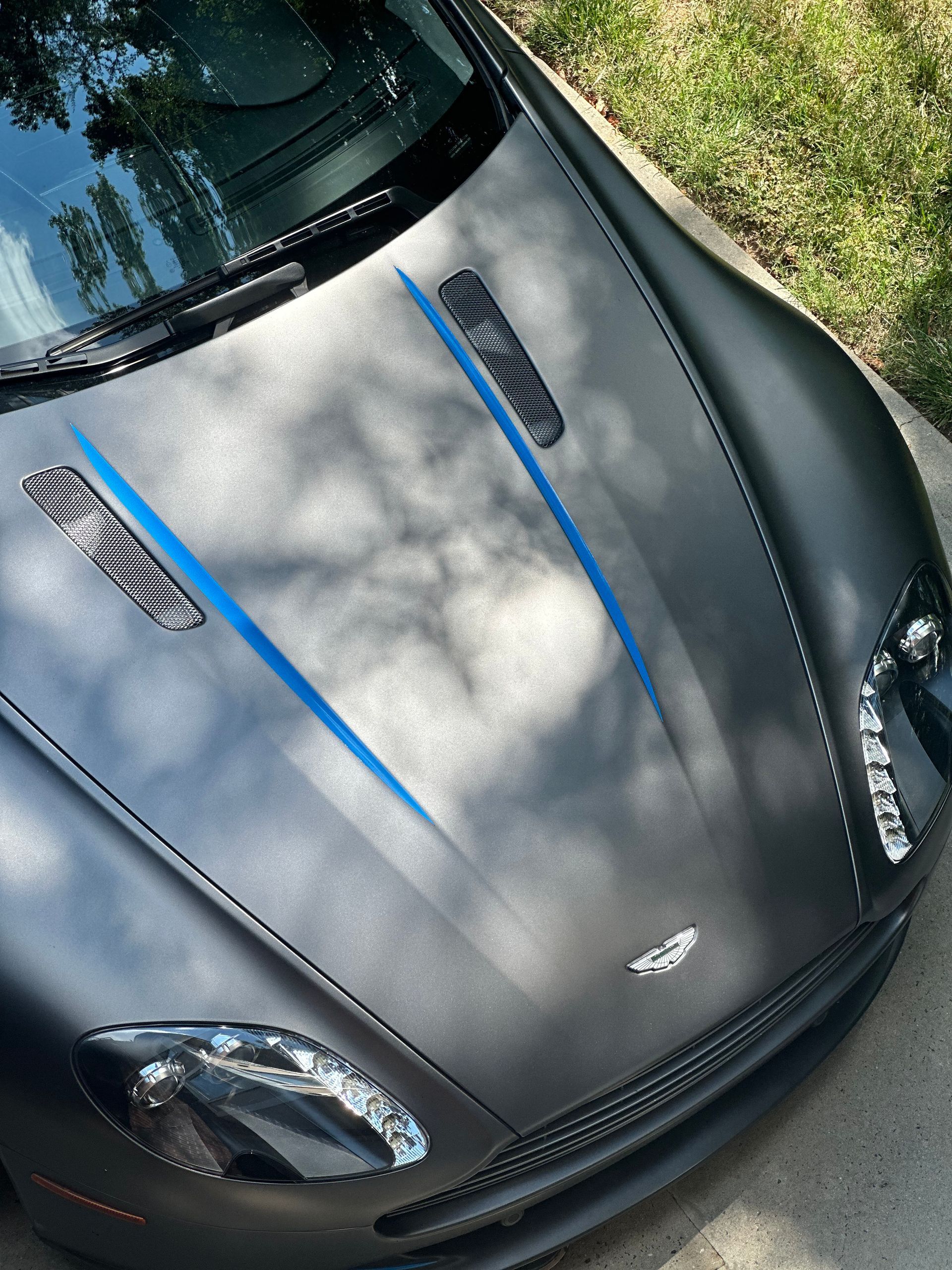 A black car with a blue stripe on the hood