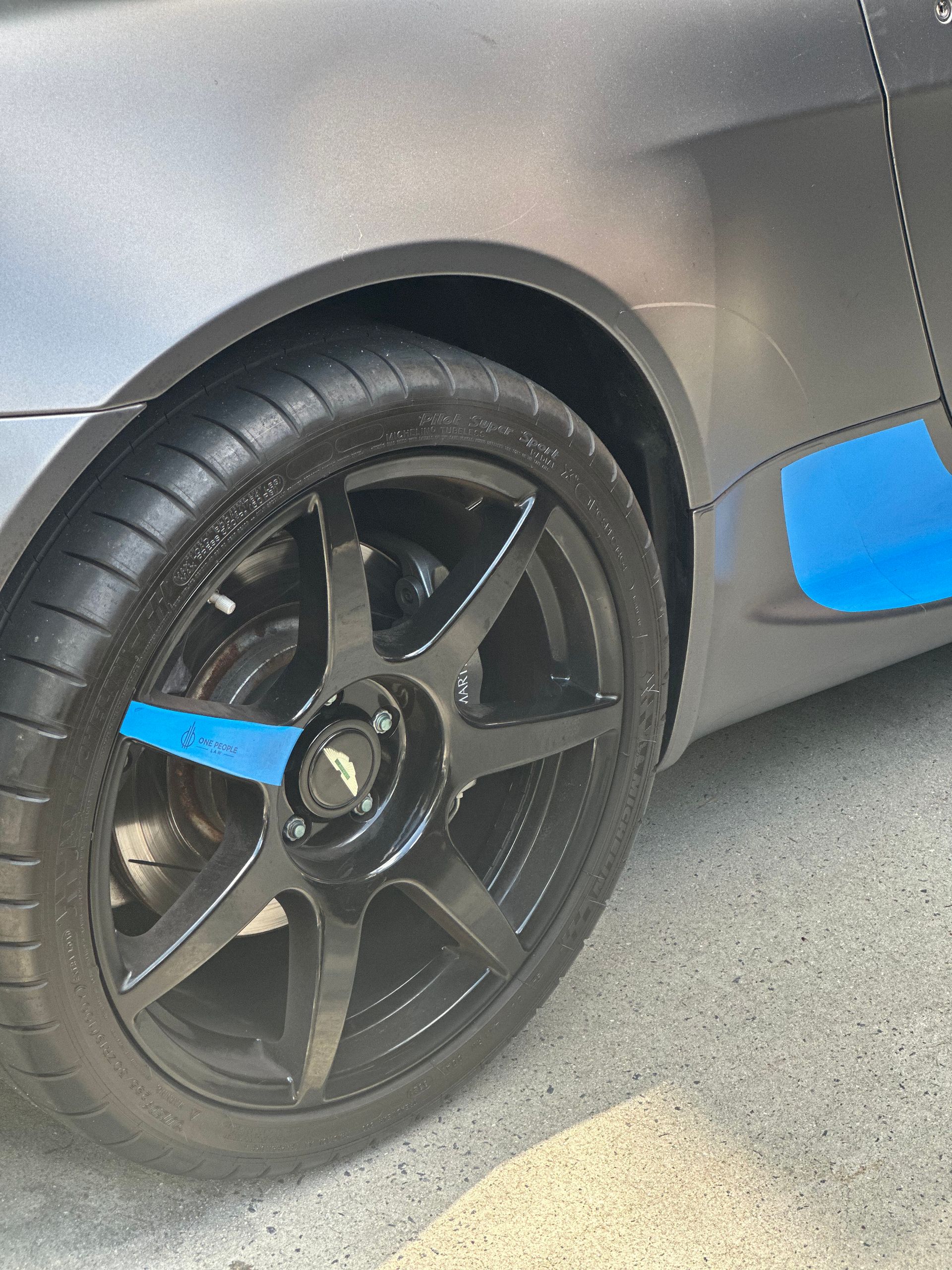 A close up of a car wheel with a blue stripe on it.