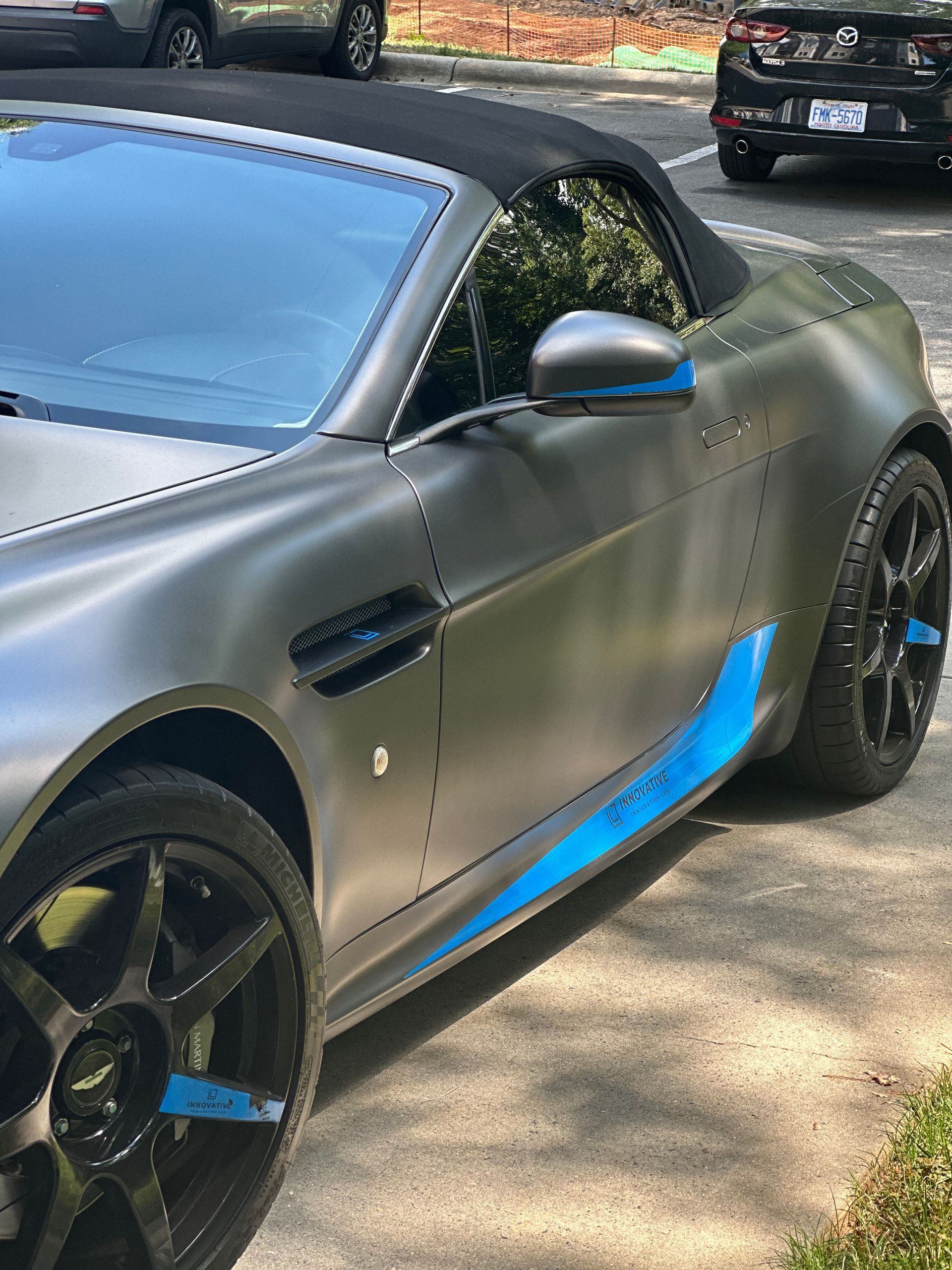 A convertible sports car is parked on the side of the road.