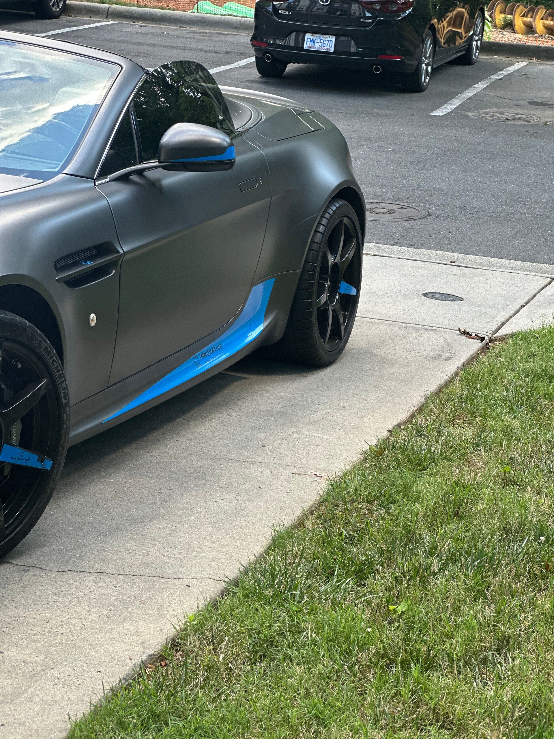 A black sports car is parked on the side of the road.