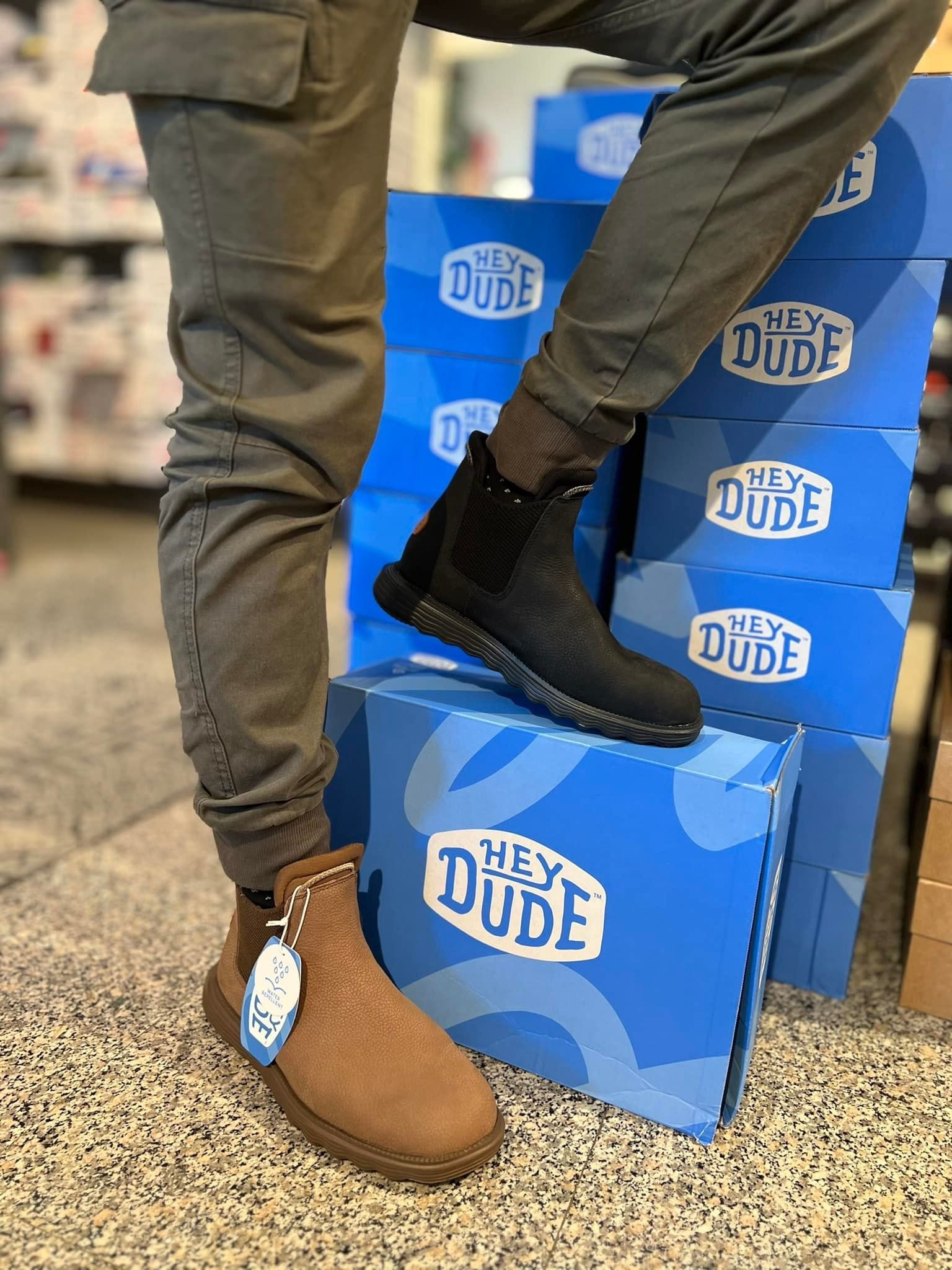 Un uomo indossa uno stivale nero su una scatola blu con la scritta 