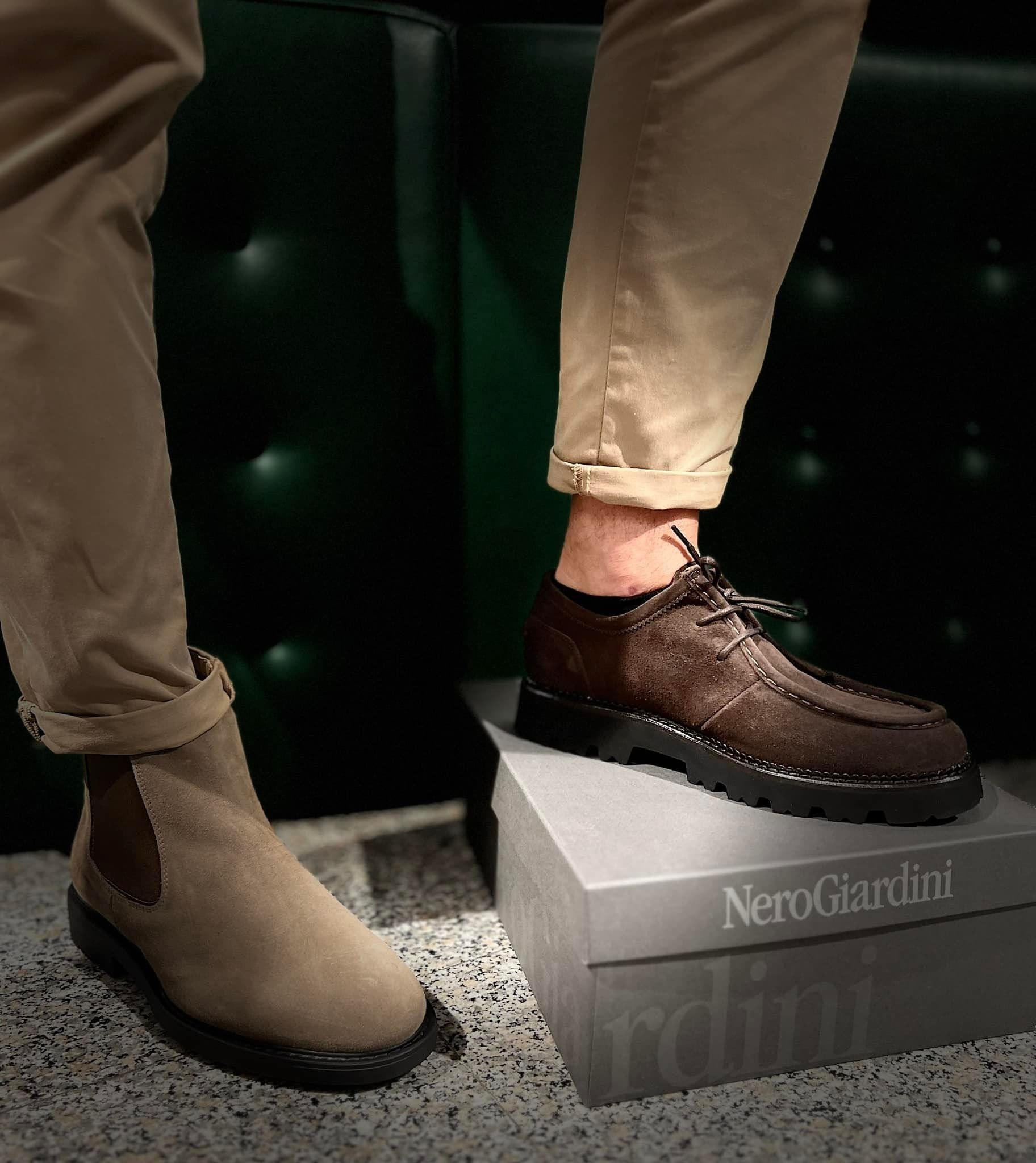 Pantaloni color cuoio con stivaletti e scarpe marroni stringate esposti su una scatola.