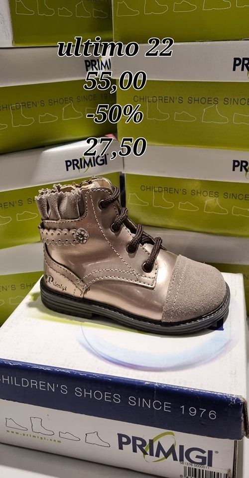 Uno stivale Primigi rosa metallizzato e grigio su una scatola. Il testo indica la taglia 22, prezzo di vendita 27,50 €.