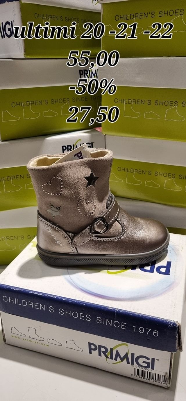 Stivale per bambini color argento con dettaglio a stella, appoggiato su una scatola da scarpe Primigi