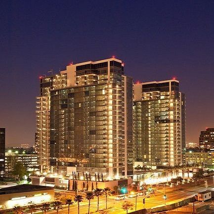 a group of tall buildings are lit up at night in a city .