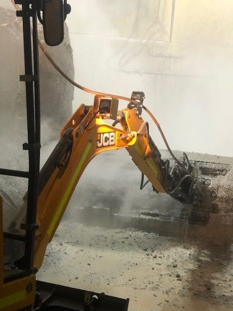 A machine is spraying concrete on a wall.