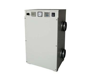 A man is sandblasting a piece of metal in a factory.