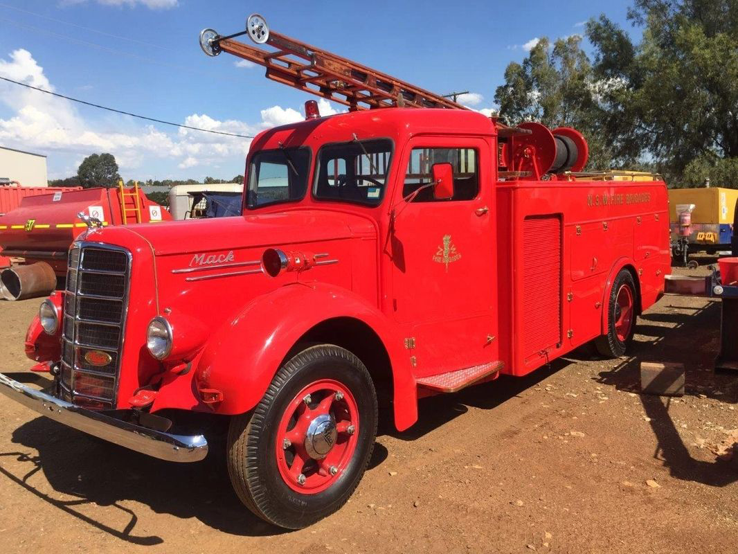 An old red fire truck with a ladder on top of it