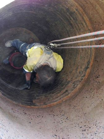 A man is laying on the ground in a hole.