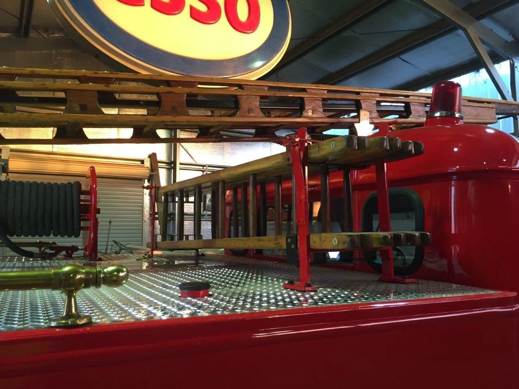 A red fire truck with a gasoline sign above it