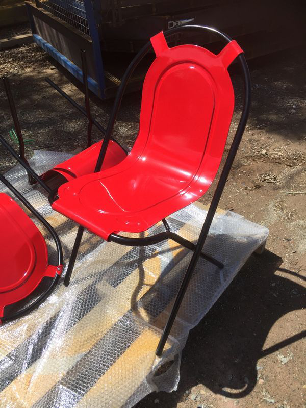 A red chair is sitting on a piece of plastic