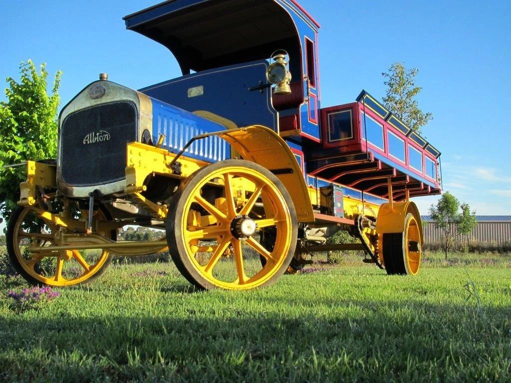 A blue and yellow truck is parked in a grassy field