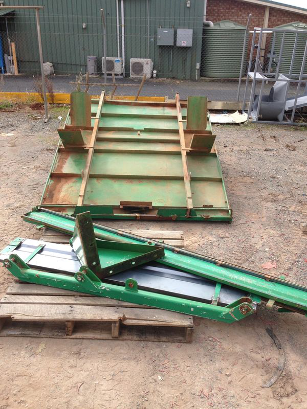 A green metal structure is sitting on top of a wooden pallet.