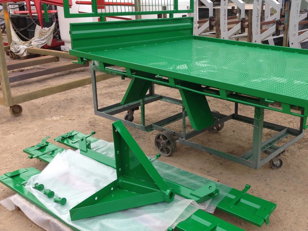 A green table with wheels is sitting on the ground.
