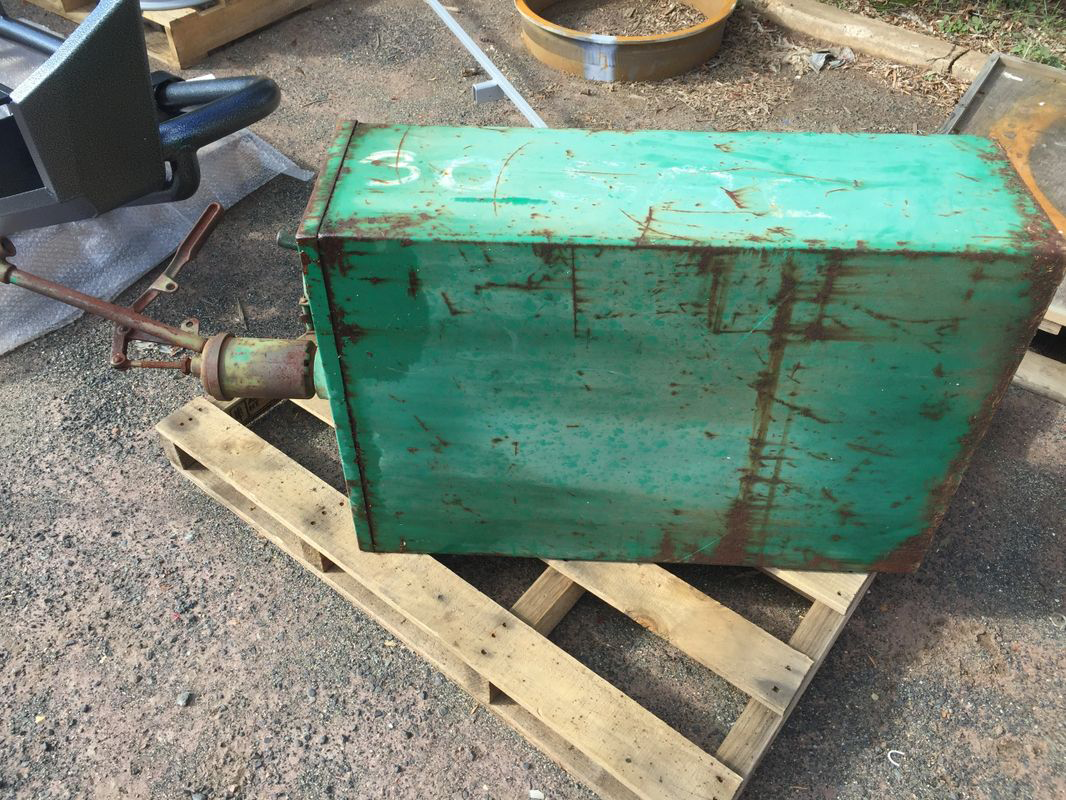 A green tank is sitting on top of a wooden pallet.