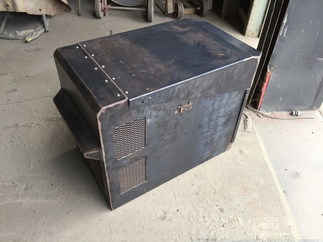 A large metal box is sitting on the ground in a garage.