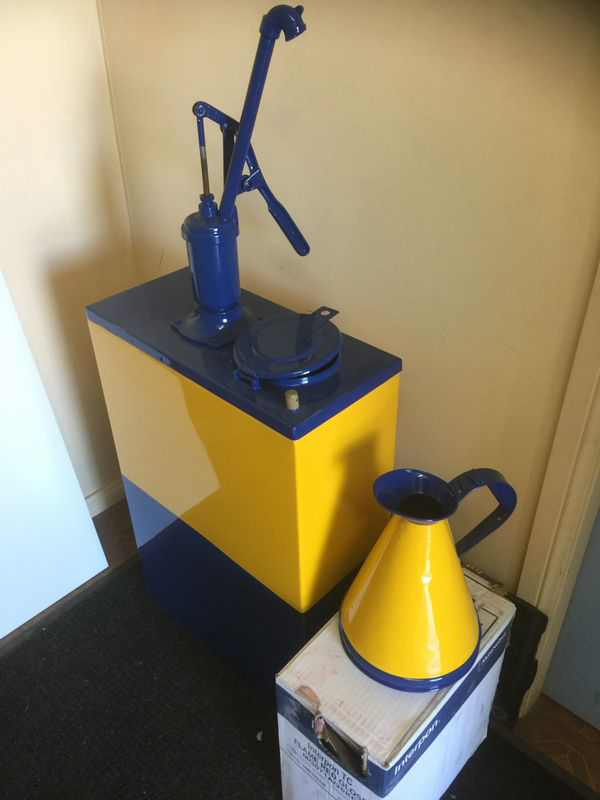 A yellow and blue container with a blue pump on top of it