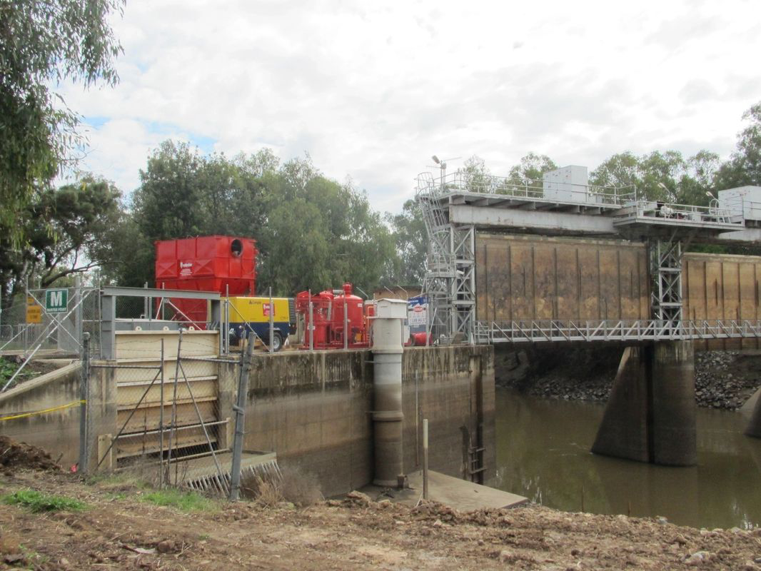 A bridge over a river with a red truck in the background.