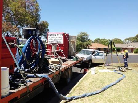A truck with a hose attached to it is parked on the side of the road.
