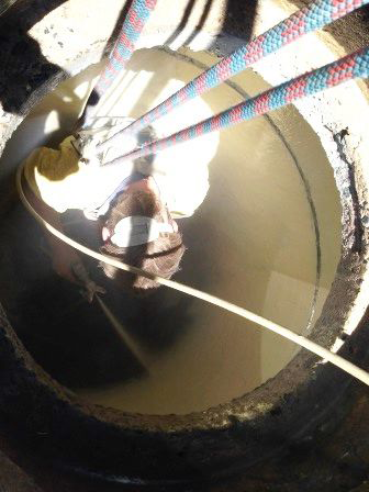 A person is standing in a hole filled with water.