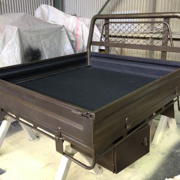 A bed with a black mattress and a metal frame