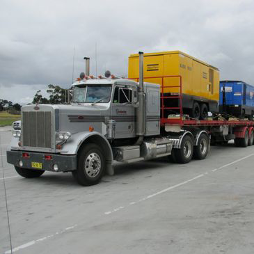 A semi truck with a yellow box on the back of it