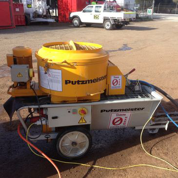 A putzmeister mixer is sitting on a trailer in a parking lot