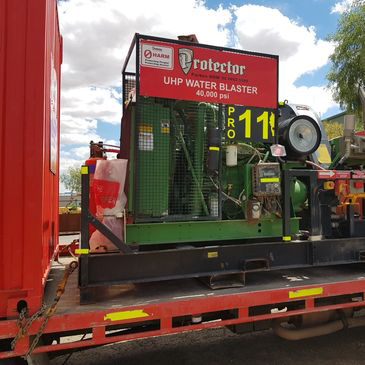 A machine with a hose attached to it is on a train track