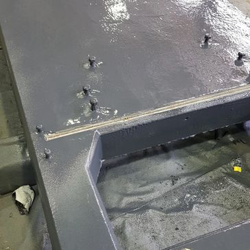 A close up of a metal structure with screws in it.