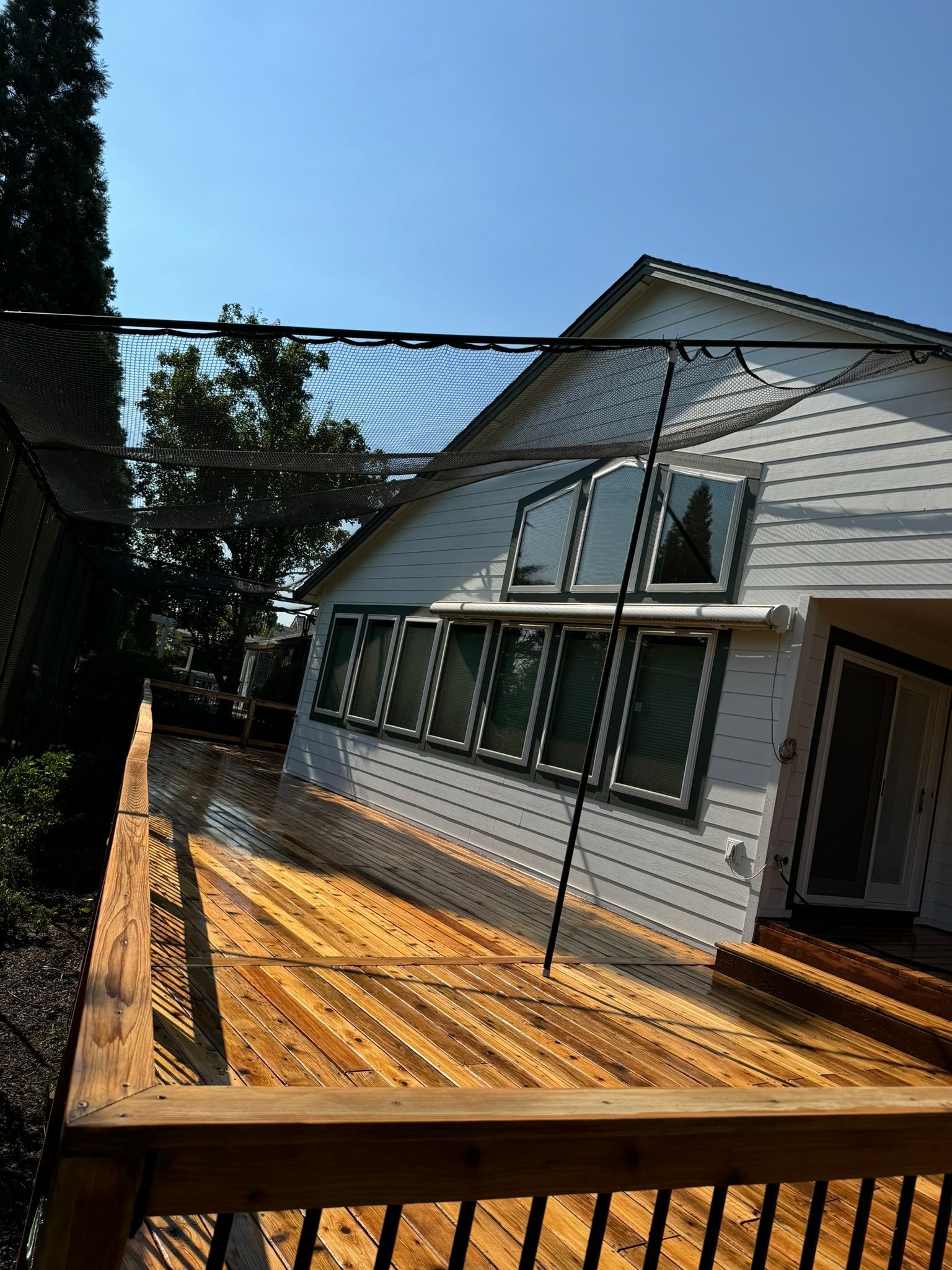 A white house with a wooden deck in front of it.